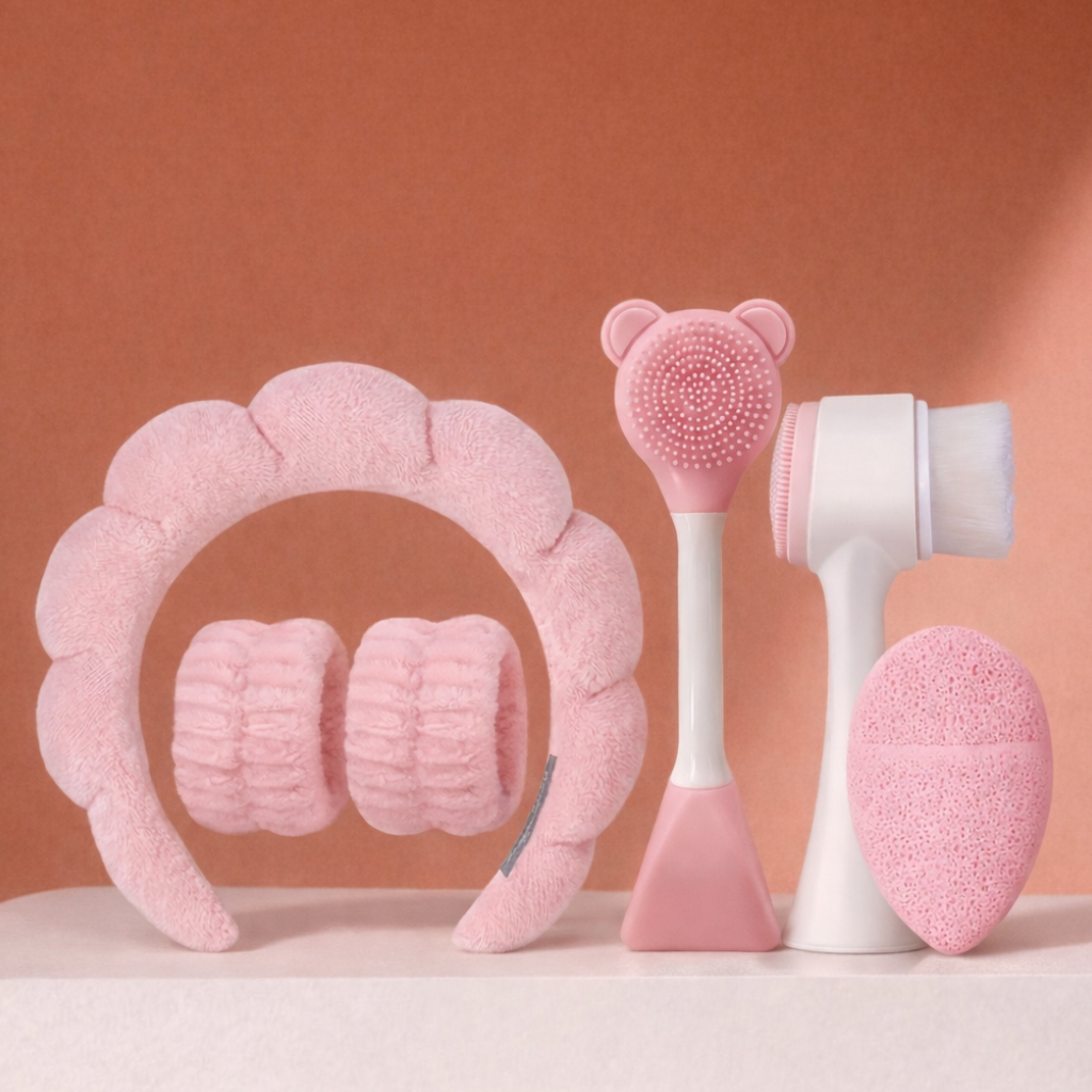 Set of pink and white skincare tools on a peach background