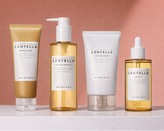 Four Centella SKIN 1004 skincare products from the brand 'Skinceed' on a pink background